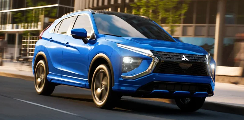 A blue 2025 Mitsubishi Eclipse Cross driving down the road.