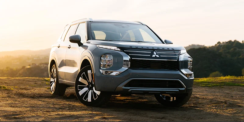 A photo of a 2025 Mitsubishi Outlander with a sunrise in the backround.